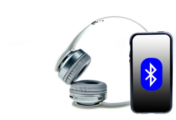 Modern wireless earbuds with charging case representing Bluetooth 5.3 and 5.4 technology comparison.