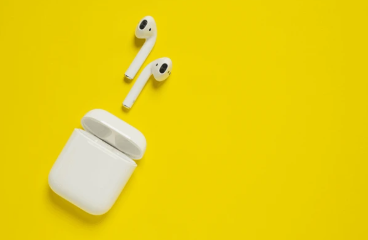 "Wireless earbuds with charging case on yellow background – ideal for Bluetooth 5.3 vs 5.4 smart wireless tech comparison"


